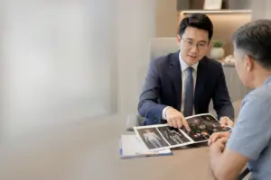 Consultant urologist explaining PSMA PET-CT scan results to a patient during a prostate cancer consultation.